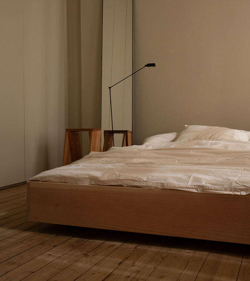 The Floating Bed av den svenske møbelsnekkeren Axel Wannberg er en minimalistisk seng laget av massiv svensk furu, som svever over gulvet for å skape en lett og rolig atmosfære. Bildet viser Teklla Bedding Winter White og Lumina Daphne gulvlampe hos Kråkvik & D´Orazio. Fåes ved Kollekted by som er en interiørforretning på Grünerløkka i Oslo.

