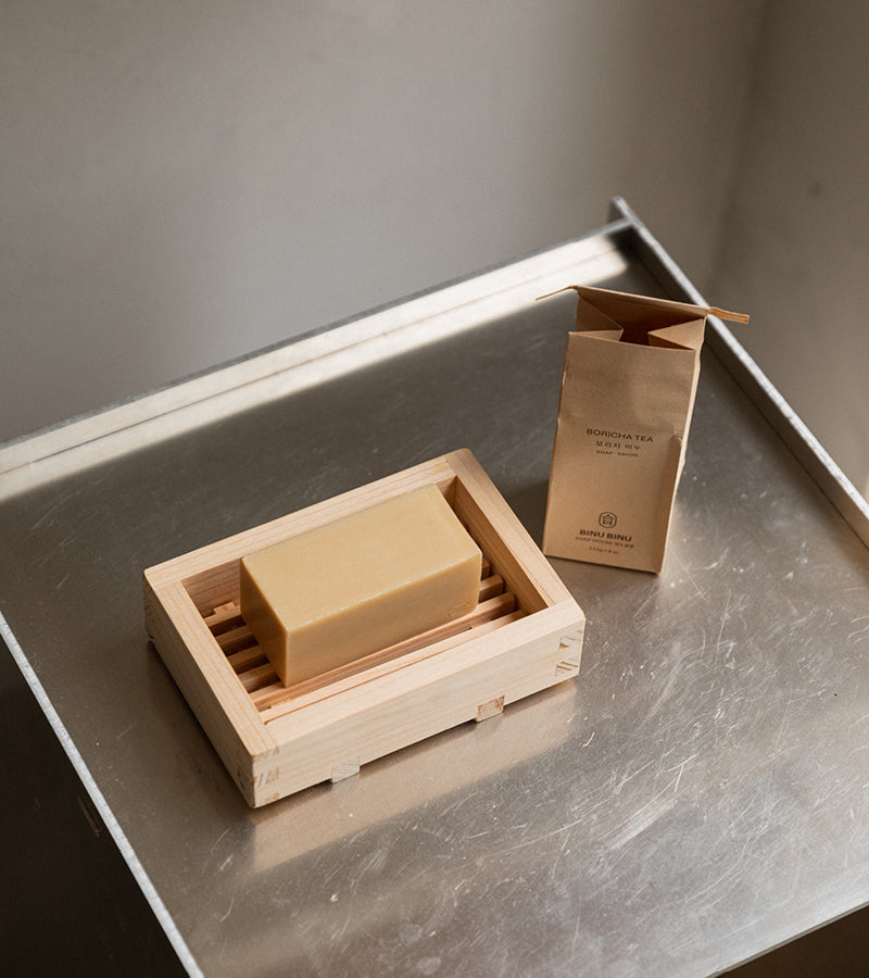 Boricha Tea såpestykke fra den Koreanske velvære produsenten Binu Binu som inneholder Boricha te. Bildet er fra Kollekted by en interiørforretning i Oslo. Viser såpetykket i en Hinoki såpeskål